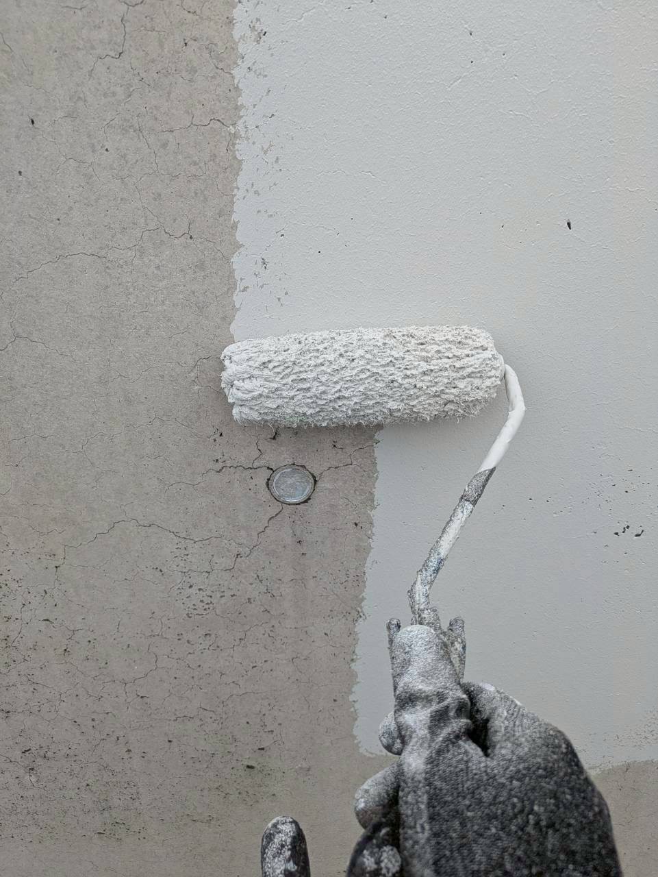 中塗り作業中のコンクリート外壁